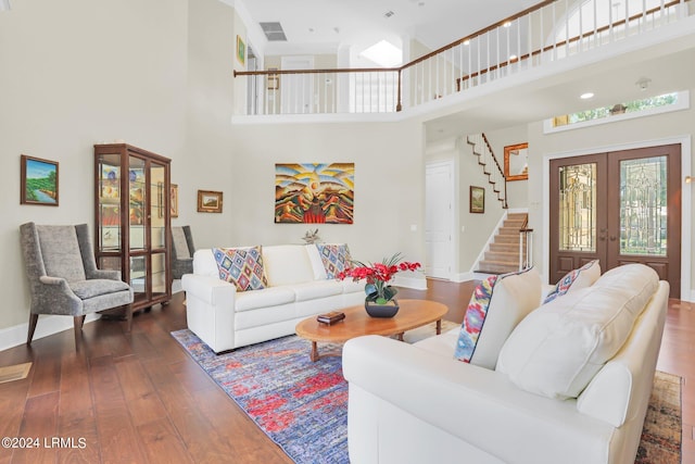 living room with dark hardwood / wood-style flooring, french doors, and a high ceiling