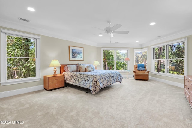 carpeted bedroom with ceiling fan, ornamental molding, and multiple windows