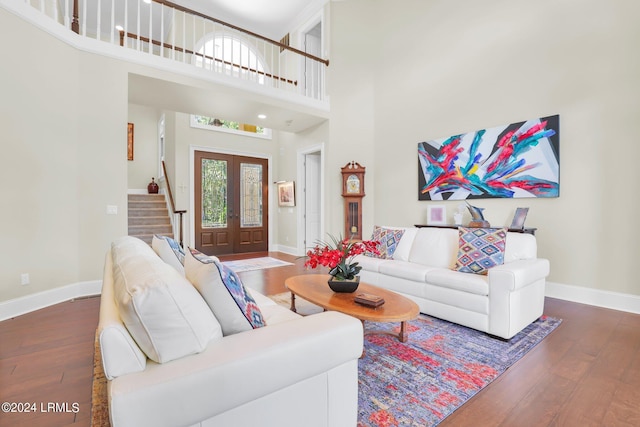 living room with a towering ceiling and dark hardwood / wood-style floors