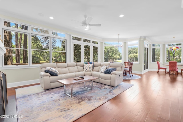 sunroom / solarium with ceiling fan with notable chandelier