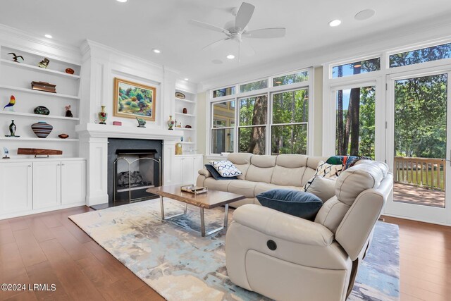 living room featuring dark hardwood / wood-style floors, built in features, and ceiling fan