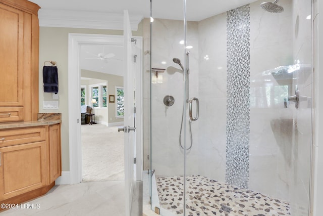 bathroom with ceiling fan, ornamental molding, and a shower with shower door