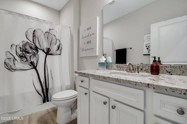 full bathroom featuring hardwood / wood-style flooring, vanity, shower / bathtub combination with curtain, and toilet