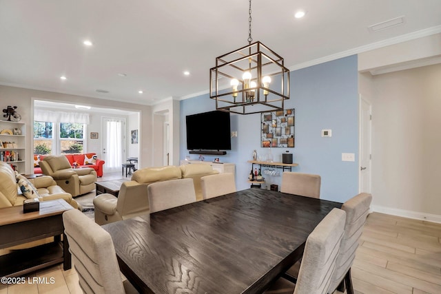 dining room featuring ornamental molding, a chandelier, and light hardwood / wood-style flooring