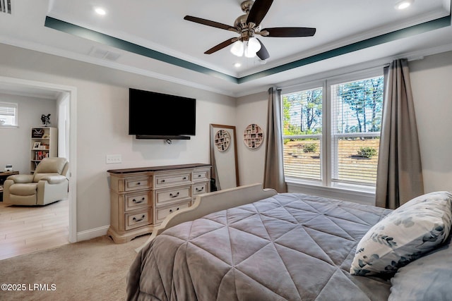 bedroom with crown molding, ceiling fan, a tray ceiling, and carpet floors