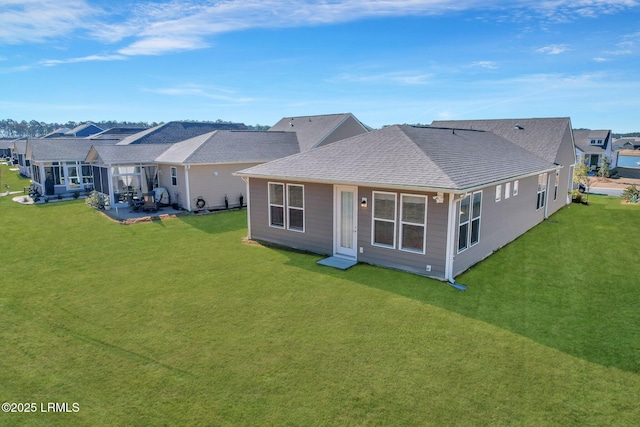 back of property with a lawn and a patio