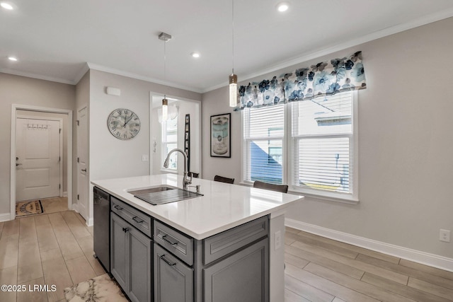 kitchen with sink, gray cabinetry, decorative light fixtures, stainless steel dishwasher, and an island with sink