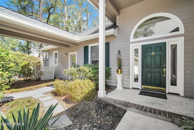 property entrance with covered porch and roof with shingles