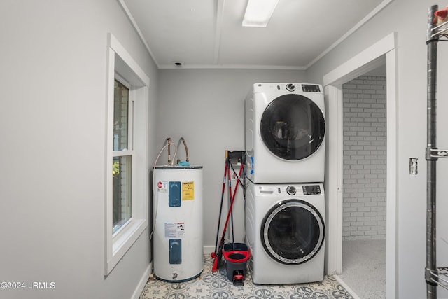 clothes washing area featuring ornamental molding, stacked washer and clothes dryer, electric water heater, and laundry area