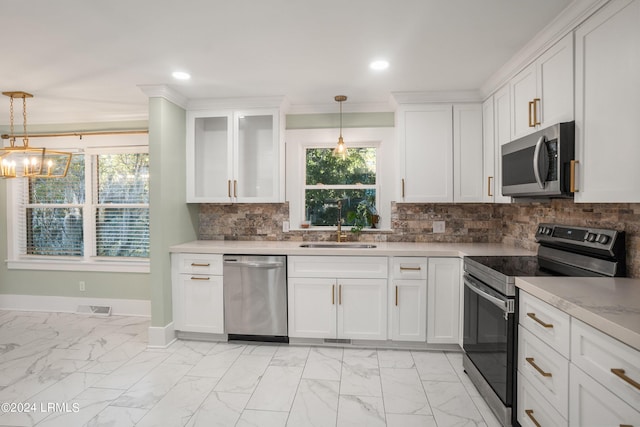 kitchen featuring stainless steel appliances, hanging light fixtures, and white cabinets