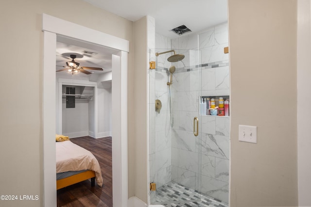 full bathroom featuring a marble finish shower, a ceiling fan, wood finished floors, and ensuite bathroom