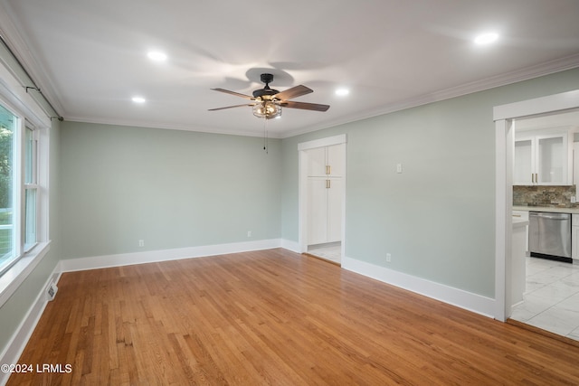 unfurnished room with light wood finished floors, ornamental molding, and baseboards