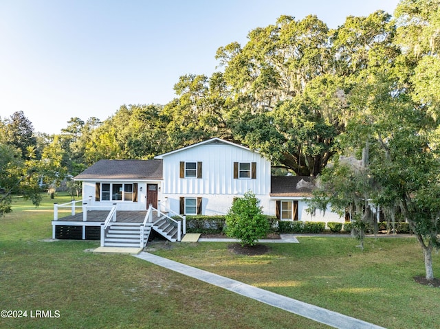 split level home featuring board and batten siding, a front lawn, and stairs