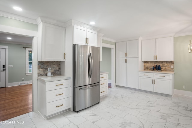 kitchen featuring marble finish floor, white cabinetry, light countertops, and freestanding refrigerator