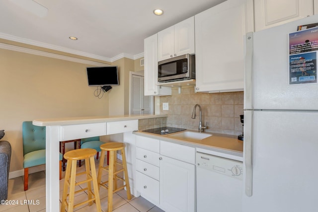 kitchen with light tile patterned floors, crown molding, white appliances, white cabinets, and decorative backsplash