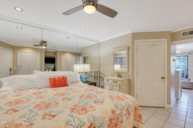 tiled bedroom with sink, two closets, ornamental molding, and ceiling fan