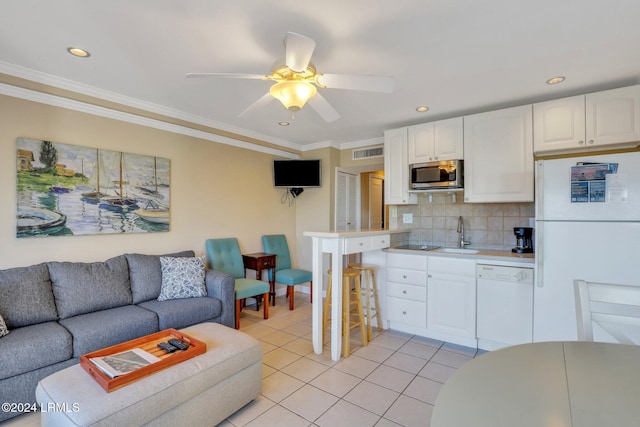 kitchen with backsplash, white cabinets, ornamental molding, light tile patterned floors, and white appliances