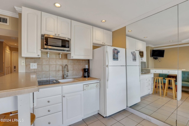 kitchen with sink, white cabinetry, light tile patterned floors, kitchen peninsula, and white appliances