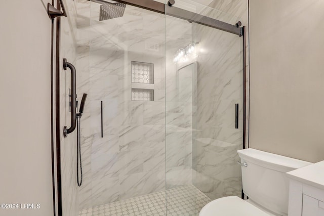 bathroom with vanity, a shower with shower door, and toilet