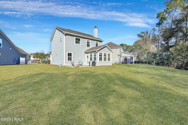 rear view of house featuring a yard and a sunroom