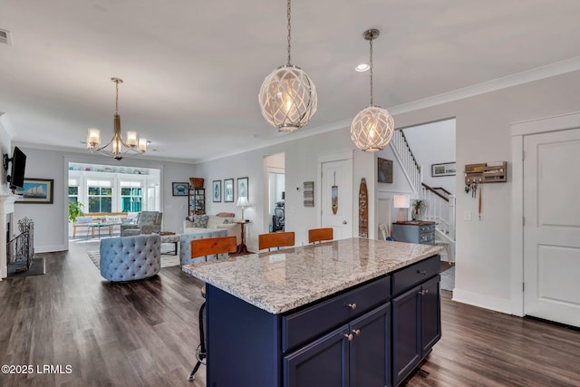 kitchen featuring decorative light fixtures, a kitchen breakfast bar, a center island, and blue cabinetry