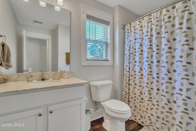 bathroom with vanity, wood-type flooring, toilet, and walk in shower