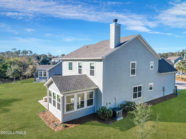 back of property with a sunroom and a lawn