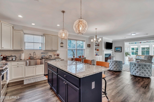 kitchen featuring sink, hanging light fixtures, a kitchen breakfast bar, stainless steel appliances, and a kitchen island