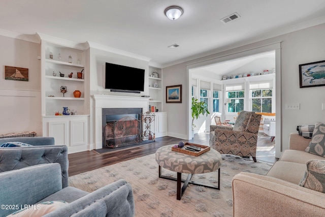 living room featuring ornamental molding, wood-type flooring, and built in features