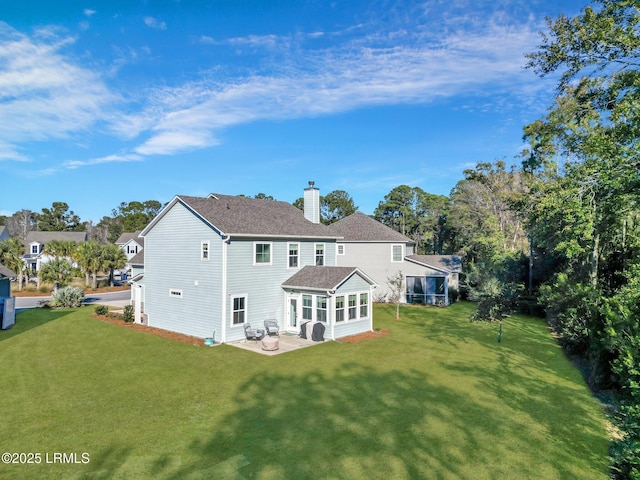 rear view of house featuring a patio, a yard, and a sunroom