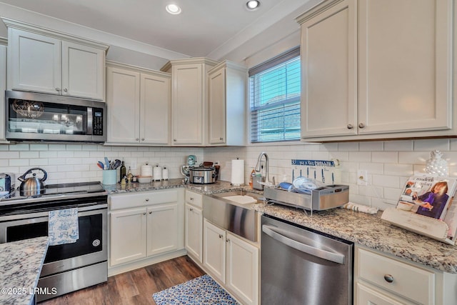 kitchen with light stone counters, backsplash, and appliances with stainless steel finishes