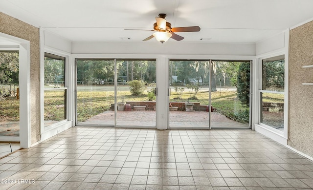 unfurnished sunroom featuring ceiling fan