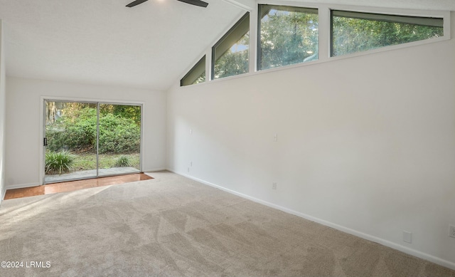 carpeted spare room featuring vaulted ceiling and ceiling fan