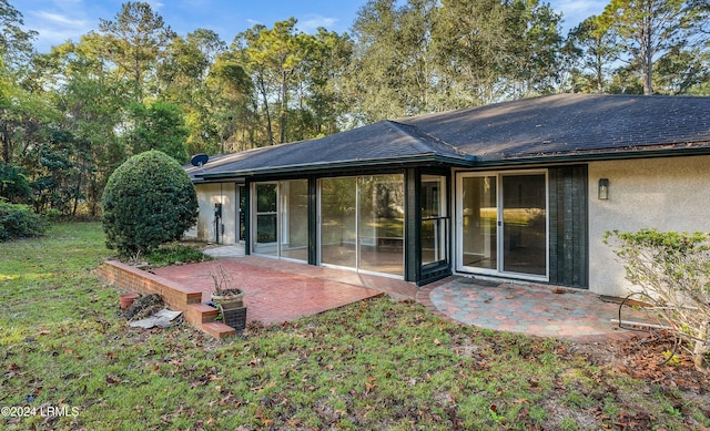 rear view of property featuring a yard and a patio area