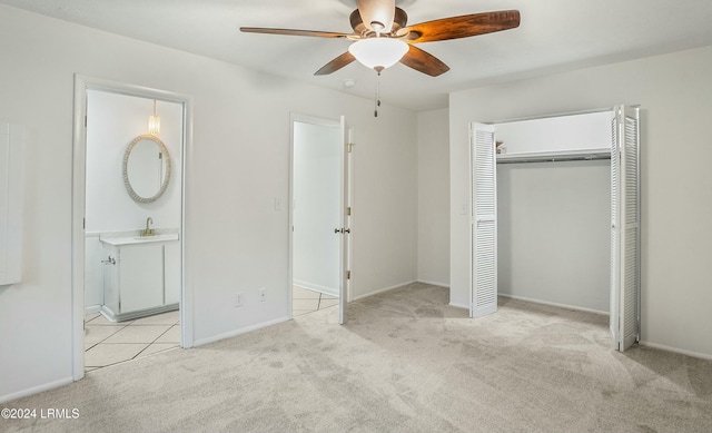 unfurnished bedroom with ceiling fan, ensuite bathroom, and light colored carpet