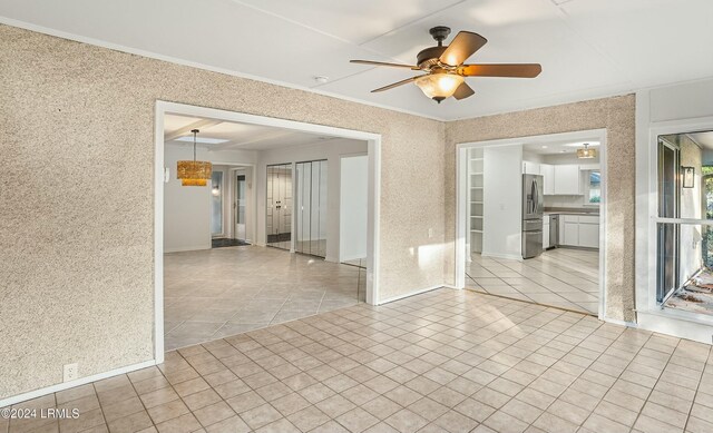 empty room with ceiling fan and light tile patterned floors