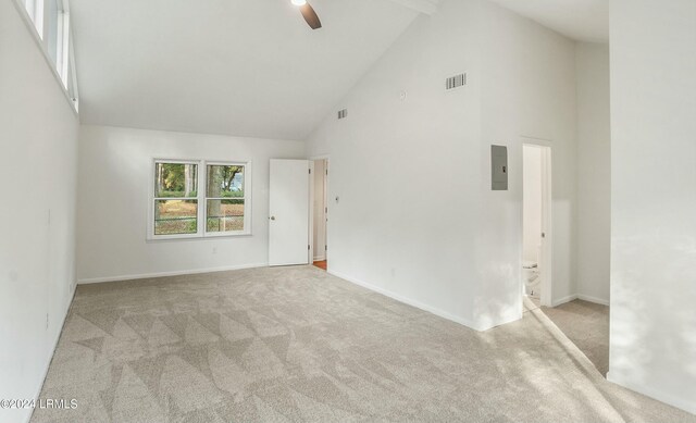 carpeted empty room featuring beamed ceiling, ceiling fan, electric panel, and high vaulted ceiling