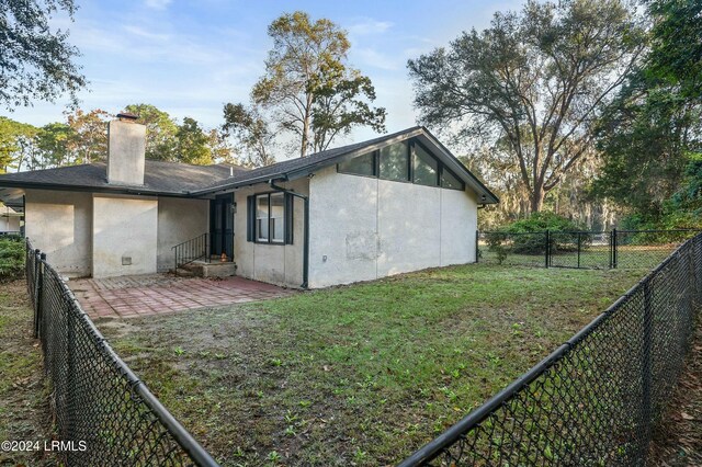 back of property featuring a yard and a patio area