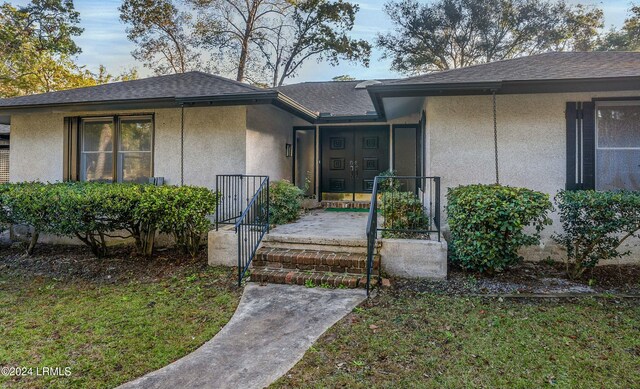 doorway to property with a yard