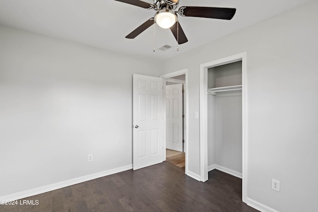 unfurnished bedroom with dark wood-type flooring, ceiling fan, and a closet