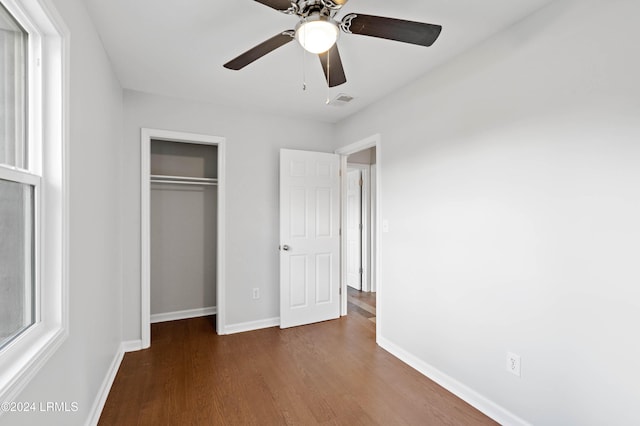 unfurnished bedroom featuring dark hardwood / wood-style floors, a closet, and ceiling fan