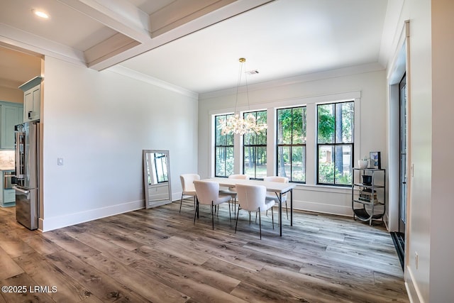 dining space featuring beamed ceiling, ornamental molding, dark wood-type flooring, and an inviting chandelier