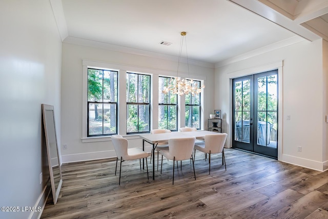 dining space featuring crown molding, an inviting chandelier, dark hardwood / wood-style flooring, and french doors