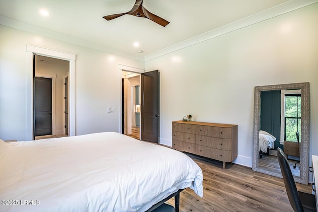 bedroom with ornamental molding, hardwood / wood-style floors, and ceiling fan