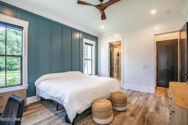 bedroom with crown molding, ceiling fan, multiple windows, and light hardwood / wood-style flooring