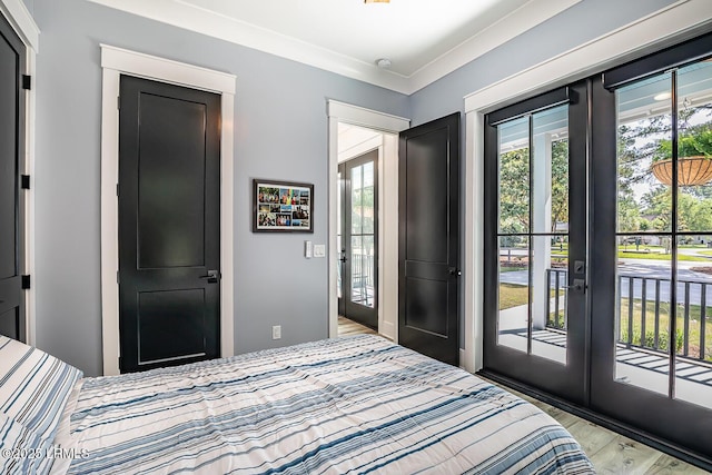 bedroom featuring french doors, light hardwood / wood-style floors, and access to outside