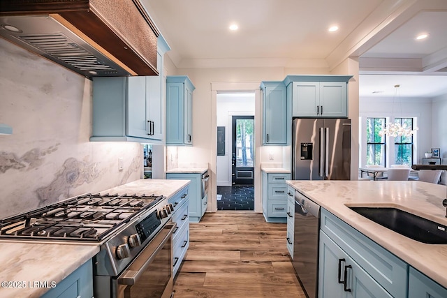 kitchen featuring crown molding, appliances with stainless steel finishes, decorative light fixtures, custom exhaust hood, and light wood-type flooring