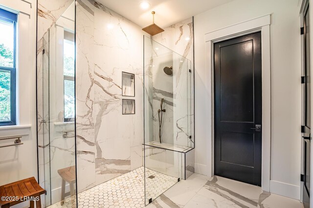 bathroom with tiled shower and plenty of natural light