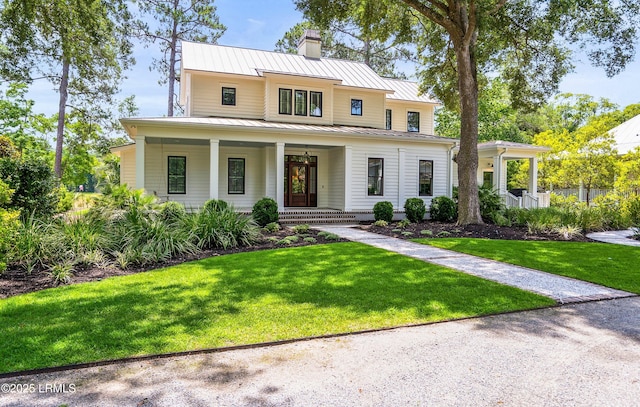 575 Distant Island Dr, Beaufort, SC 29907 - view of front of house with a standing seam roof, covered porch, a chimney, a metal roof, and a front yard