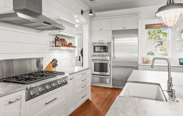 575 Distant Island Dr, Beaufort, SC 29907 - kitchen with extractor fan, built in appliances, white cabinetry, a warming drawer, and wood finished floors